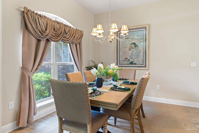 dining space with light hardwood / wood-style floors and a chandelier