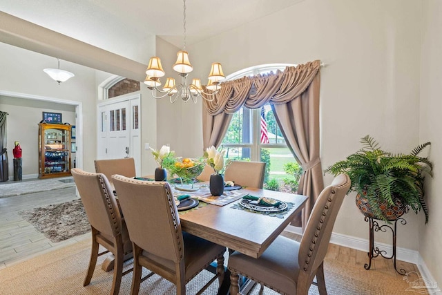 dining area with lofted ceiling and a notable chandelier