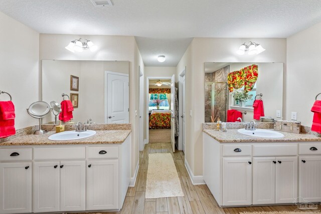 bathroom featuring dual vanity, a textured ceiling, and ceiling fan