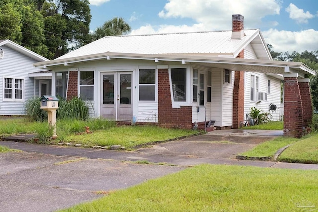 bungalow with a front lawn and french doors