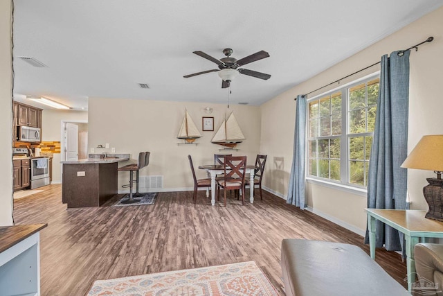 dining room with light hardwood / wood-style floors and ceiling fan