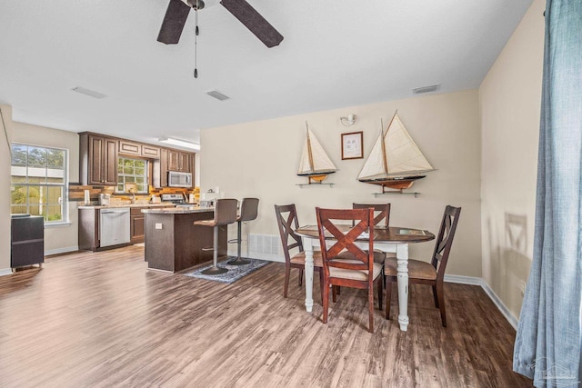 dining area featuring wood-type flooring and ceiling fan