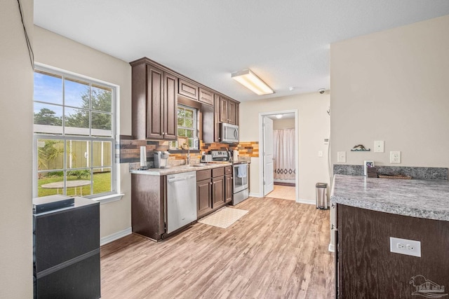 kitchen featuring decorative backsplash, stainless steel appliances, light hardwood / wood-style floors, and dark brown cabinetry