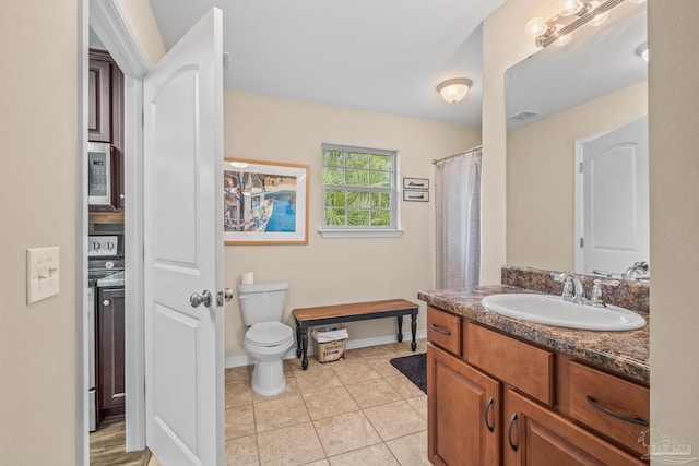 bathroom with tile patterned floors, vanity, and toilet