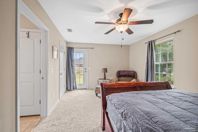 carpeted bedroom featuring multiple windows, a textured ceiling, ceiling fan, and access to exterior