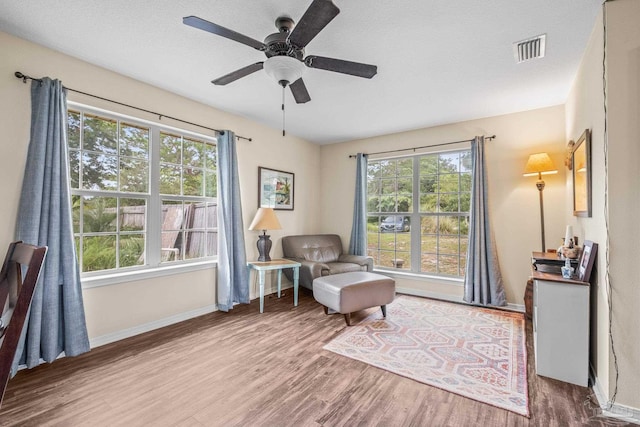 sitting room with a textured ceiling, ceiling fan, and hardwood / wood-style flooring