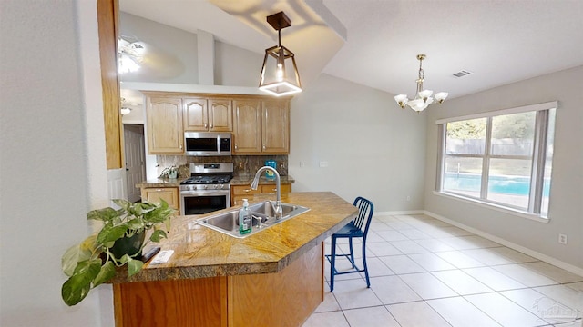 kitchen with sink, an inviting chandelier, backsplash, lofted ceiling, and appliances with stainless steel finishes