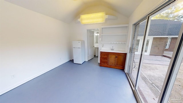 interior space featuring white refrigerator, vaulted ceiling, and sink