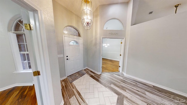 entryway featuring hardwood / wood-style floors and a towering ceiling