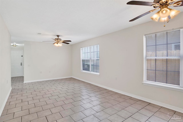 spare room featuring ceiling fan and light tile patterned floors