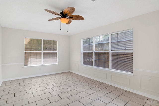 tiled empty room featuring ceiling fan