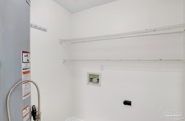 laundry area with gas water heater, hookup for an electric dryer, washer hookup, and a textured ceiling