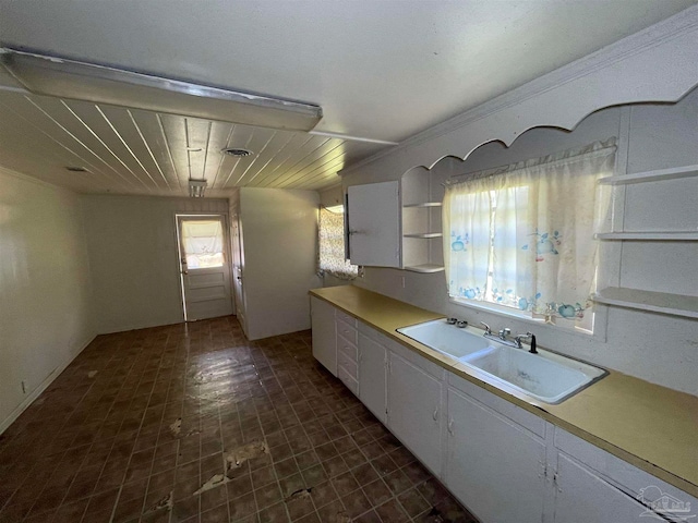 kitchen featuring sink, white cabinets, and tile patterned flooring