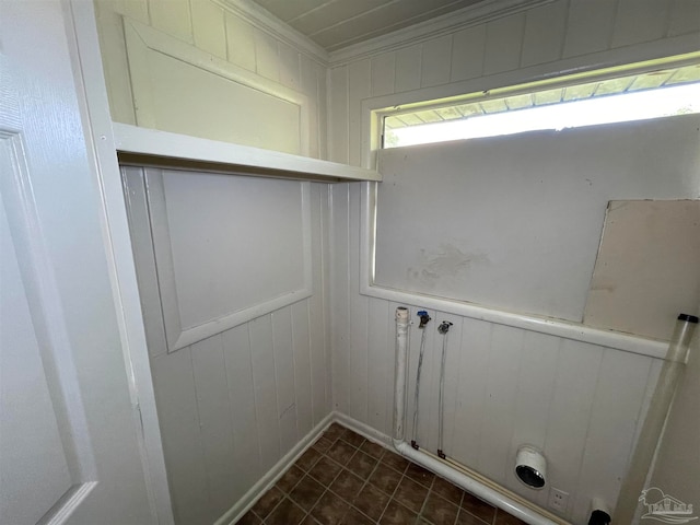 clothes washing area with dark tile patterned floors