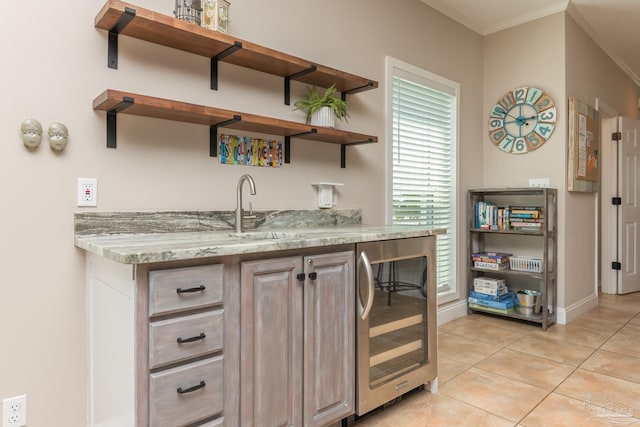 bar with crown molding, a sink, beverage cooler, indoor wet bar, and light tile patterned floors