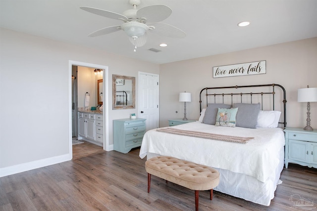 bedroom featuring visible vents, wood finished floors, baseboards, recessed lighting, and ensuite bath