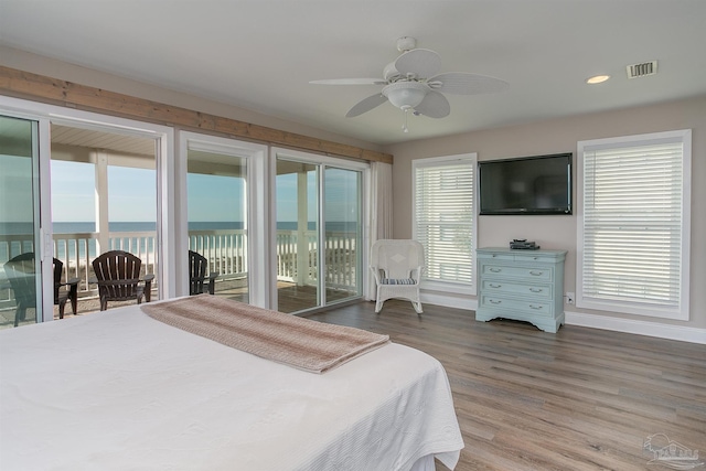 bedroom with access to exterior, a ceiling fan, baseboards, wood finished floors, and visible vents