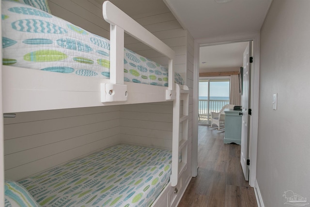 bedroom featuring a water view and wood finished floors