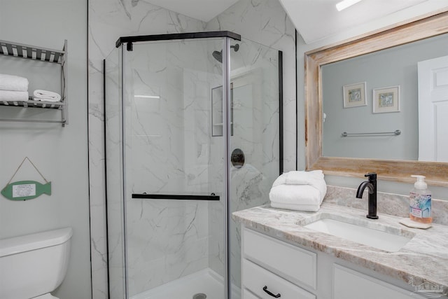 full bathroom featuring toilet, a marble finish shower, and vanity