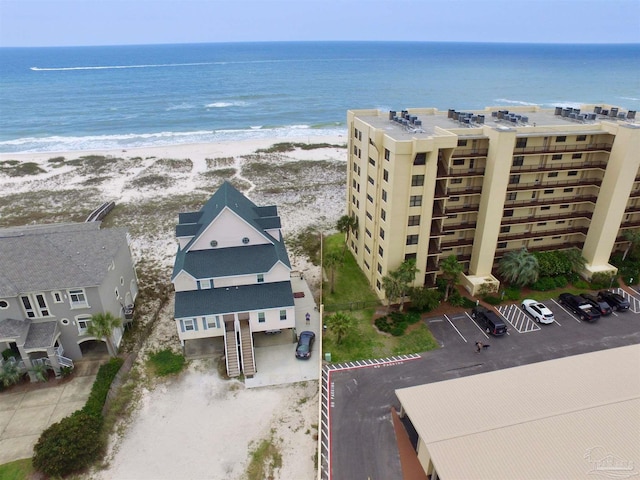 drone / aerial view featuring a water view and a view of the beach