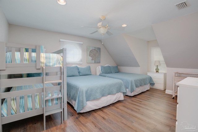 bedroom with recessed lighting, visible vents, wood finished floors, and vaulted ceiling