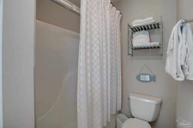 bathroom with a shower with curtain and toilet
