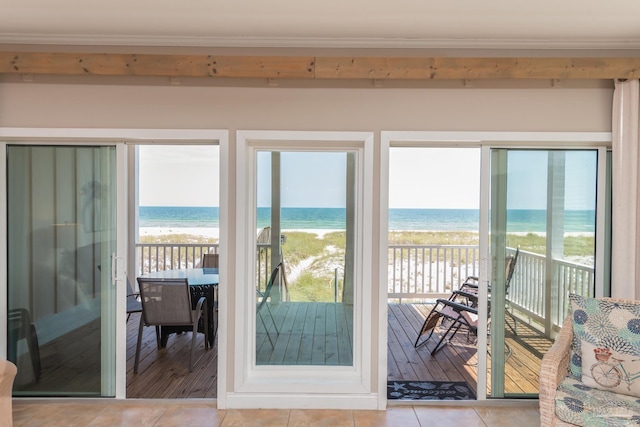 entryway featuring a water view, a view of the beach, and tile patterned flooring