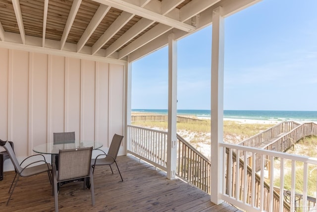 wooden terrace featuring a water view, a view of the beach, and stairway