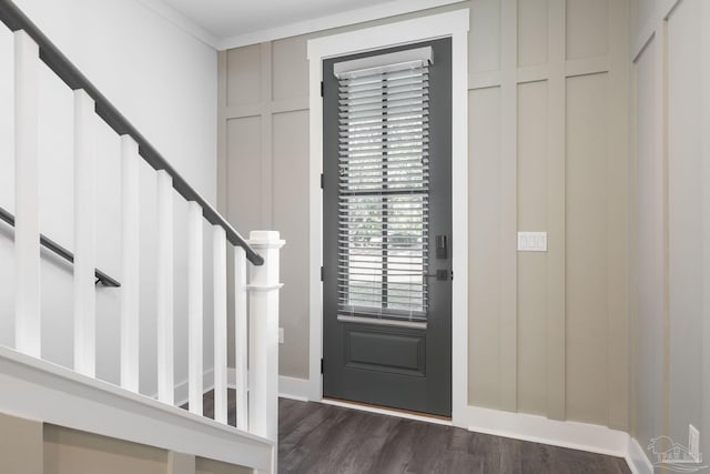 entrance foyer with ornamental molding and dark hardwood / wood-style floors