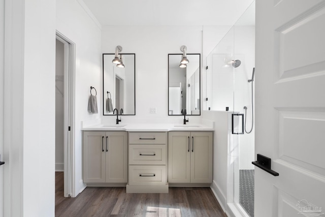 bathroom with hardwood / wood-style flooring, vanity, and a shower with shower door