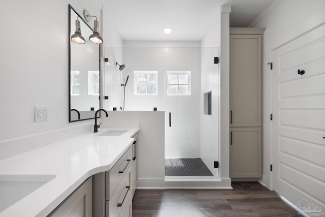 bathroom with hardwood / wood-style flooring, vanity, and an enclosed shower