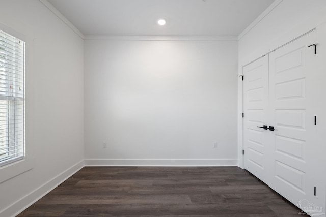 empty room featuring crown molding, dark hardwood / wood-style floors, and a healthy amount of sunlight