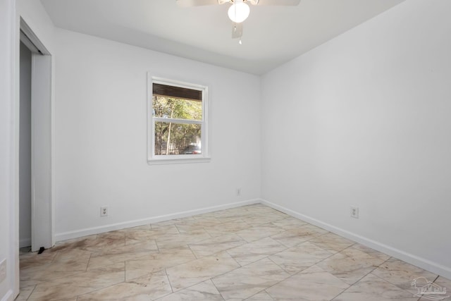 unfurnished room featuring ceiling fan and baseboards