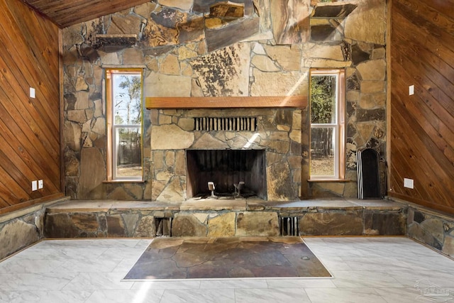 unfurnished living room featuring vaulted ceiling, a fireplace, and wood walls