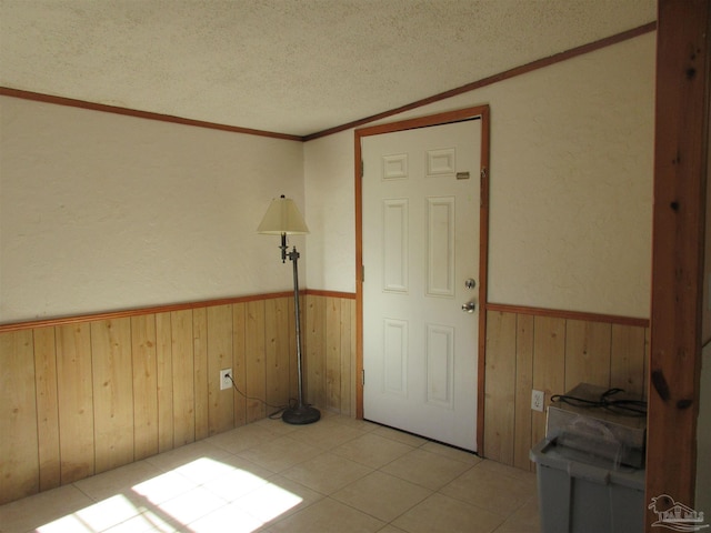 unfurnished room with a wainscoted wall, wood walls, and a textured ceiling