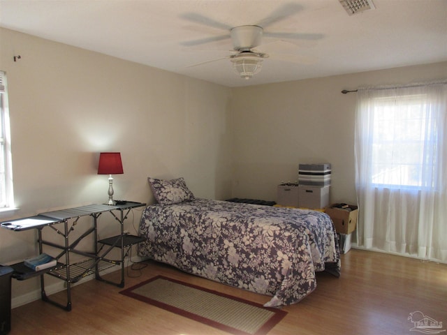 bedroom featuring ceiling fan, light wood-style flooring, and visible vents