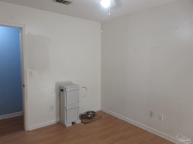 unfurnished room with visible vents, baseboards, and wood finished floors