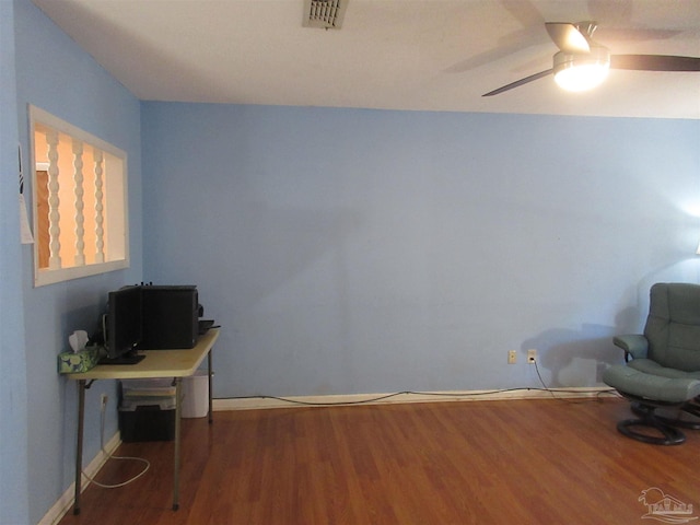 unfurnished room featuring a ceiling fan, visible vents, baseboards, and wood finished floors