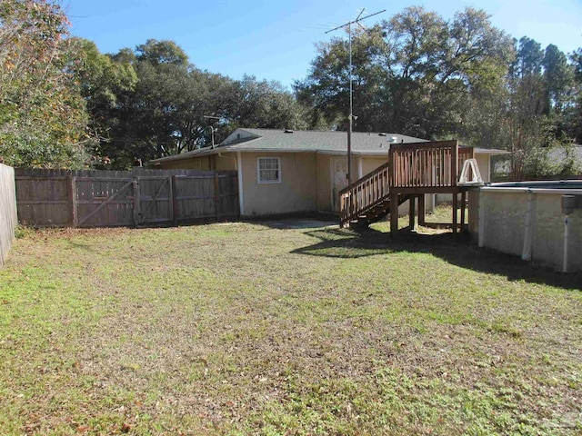 view of yard featuring a wooden deck, stairway, fence, and a fenced in pool