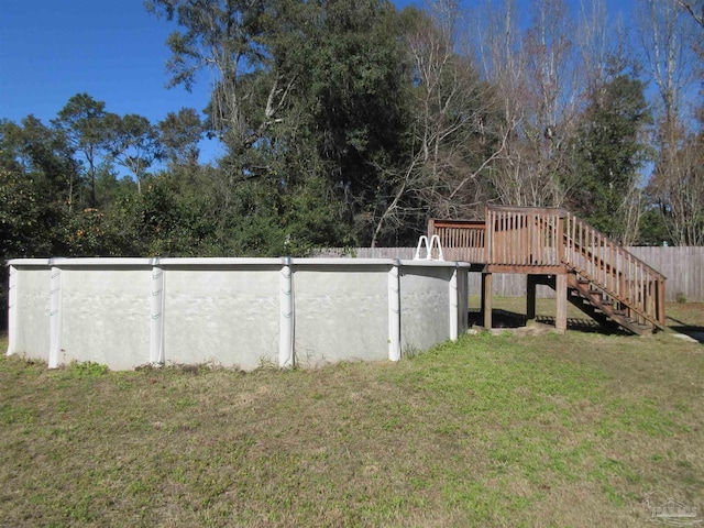 view of yard featuring a fenced in pool, fence, a deck, and stairs