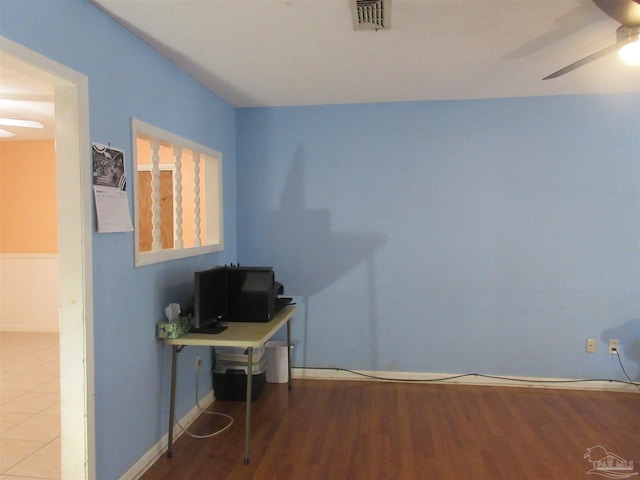 office space with visible vents, wood finished floors, a ceiling fan, and baseboards