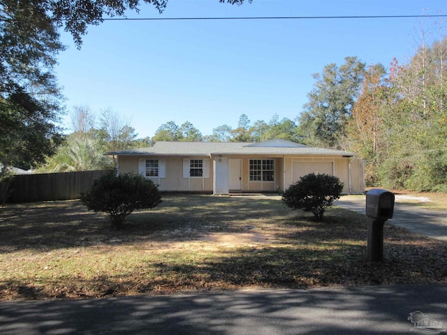 ranch-style house with an attached garage, driveway, and fence