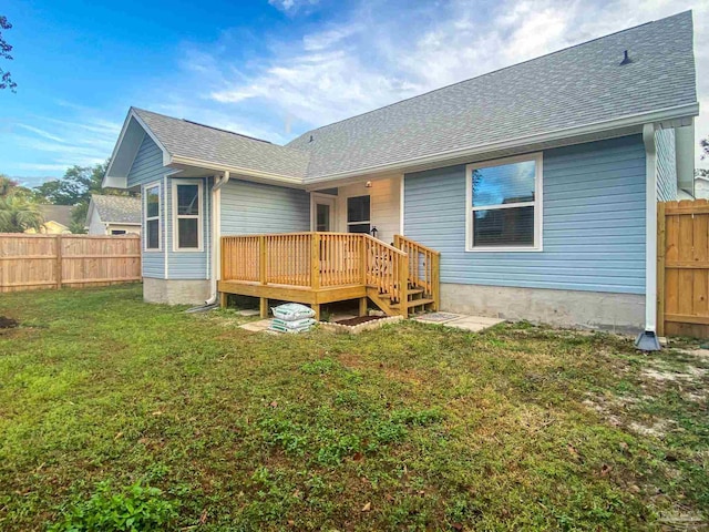 rear view of house featuring a wooden deck and a lawn