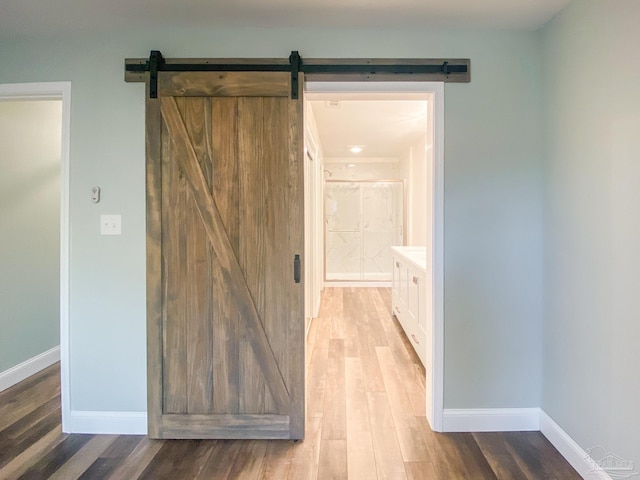 hall with a barn door and light wood-type flooring