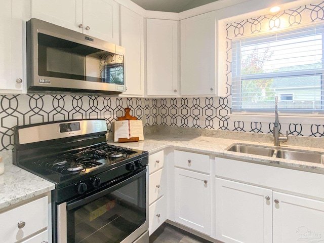 kitchen with white cabinetry, sink, tasteful backsplash, and stainless steel appliances