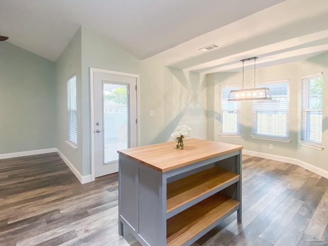 kitchen featuring lofted ceiling, dark hardwood / wood-style floors, wooden counters, and hanging light fixtures