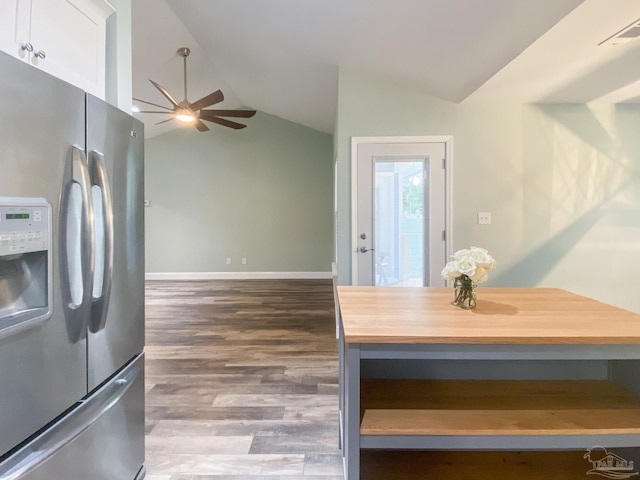 kitchen with lofted ceiling, butcher block countertops, white cabinetry, wood-type flooring, and stainless steel fridge