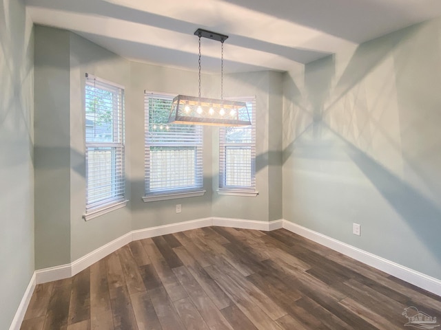 unfurnished dining area with dark wood-type flooring