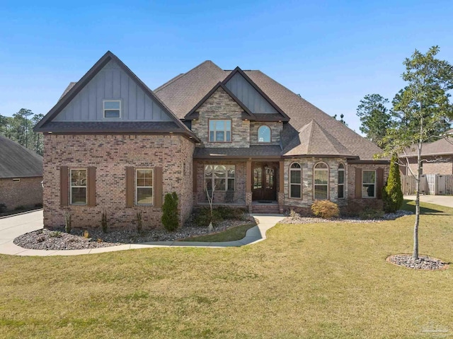 craftsman inspired home with a shingled roof, a front lawn, board and batten siding, and brick siding