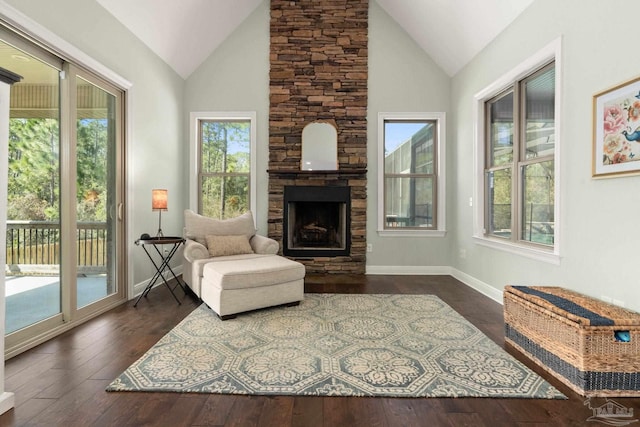 8901 Salt Grass Dr, Pensacola, FL 32526 - sitting room featuring high vaulted ceiling, dark wood finished floors, a stone fireplace, and baseboards